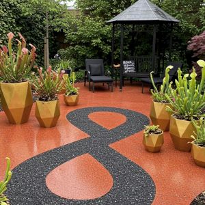 An urban garden with red marble patio and carnivorous plants in gold pots